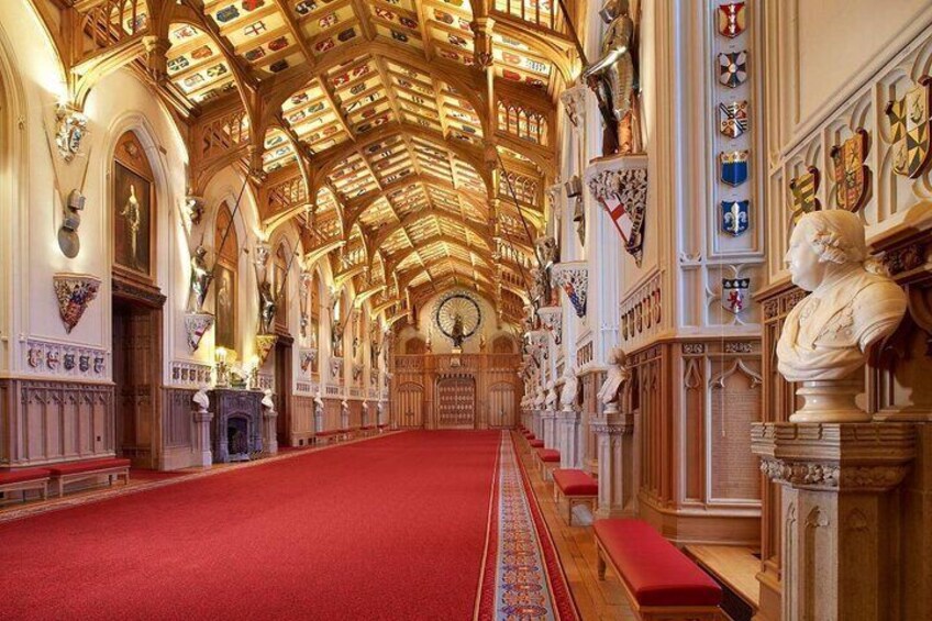 Interior de iglesia con alfombra roja, bancos de madera y un alto techo abovedado con vidrieras. 5