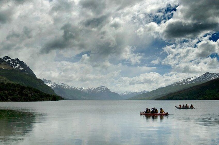 A calm lake with boats, mountains, and a cloudy sky. 4