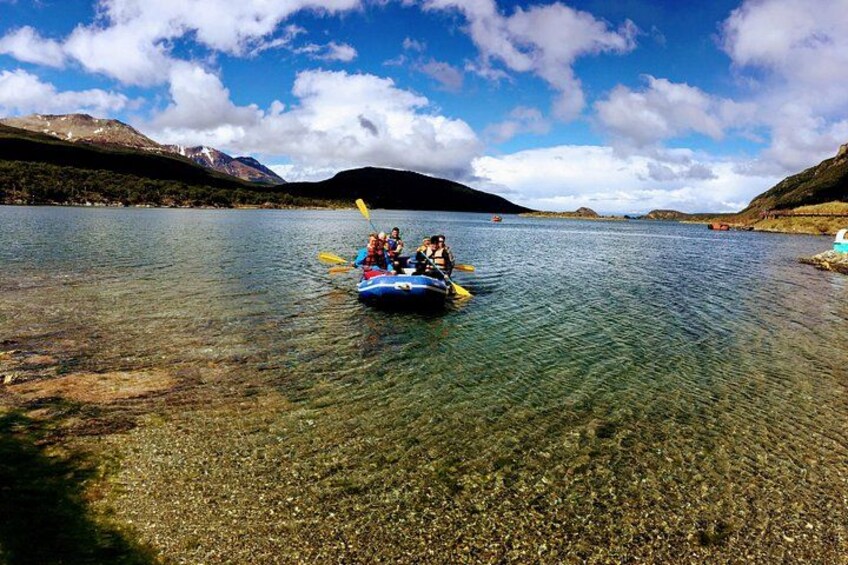 Un grupo de personas haciendo kayak en un lago tranquilo rodeado de montañas. 3