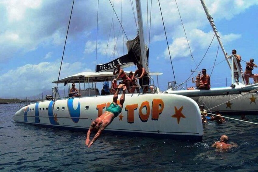 Een persoon die handstand maakt op een boot, met de tekst 'TOP' in het zicht. 1