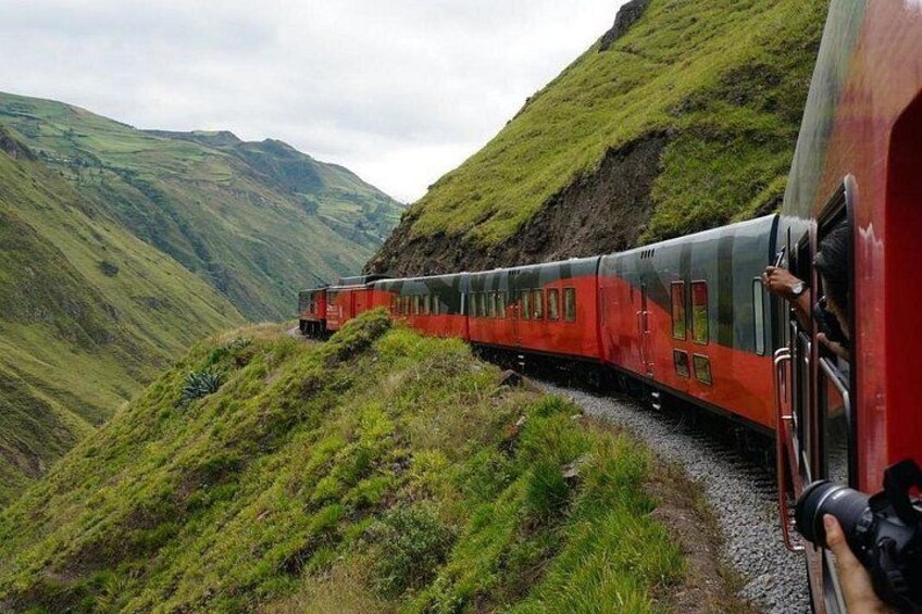 Un tren viajando a través de un paisaje montañoso. 2