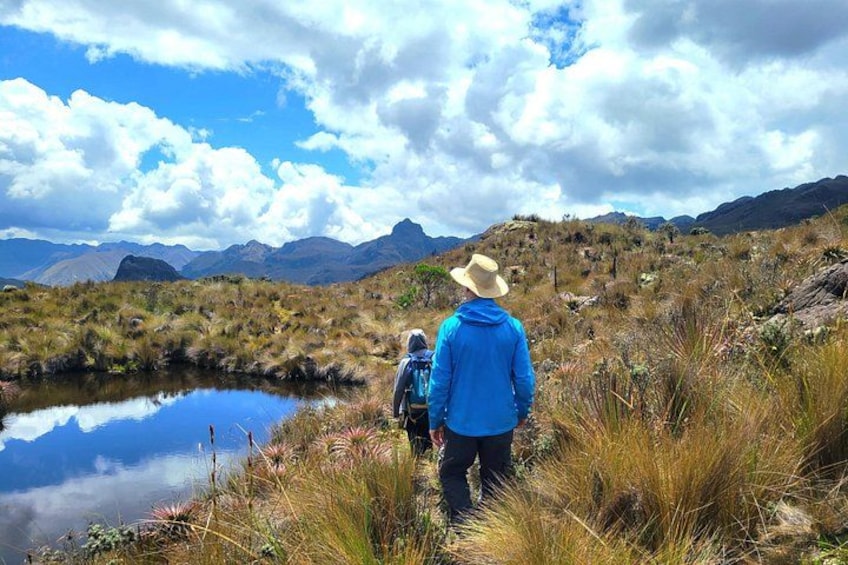 Dos personas caminando en una zona montañosa con un lago. 2
