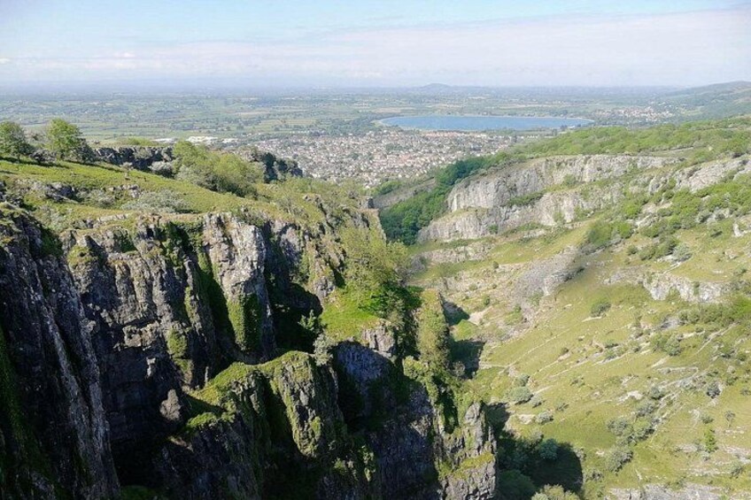 A valley with rocky cliffs and a distant town. 4