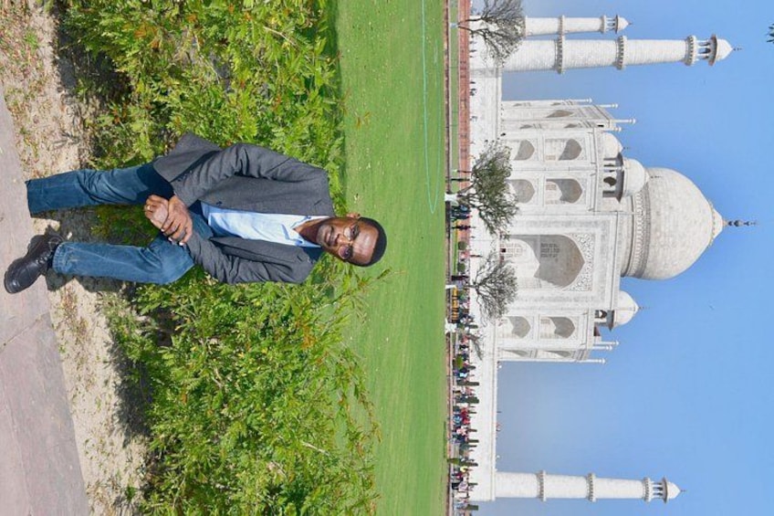 Eine Person steht vor dem Taj Mahal, der Himmel ist wolkenlos. 2