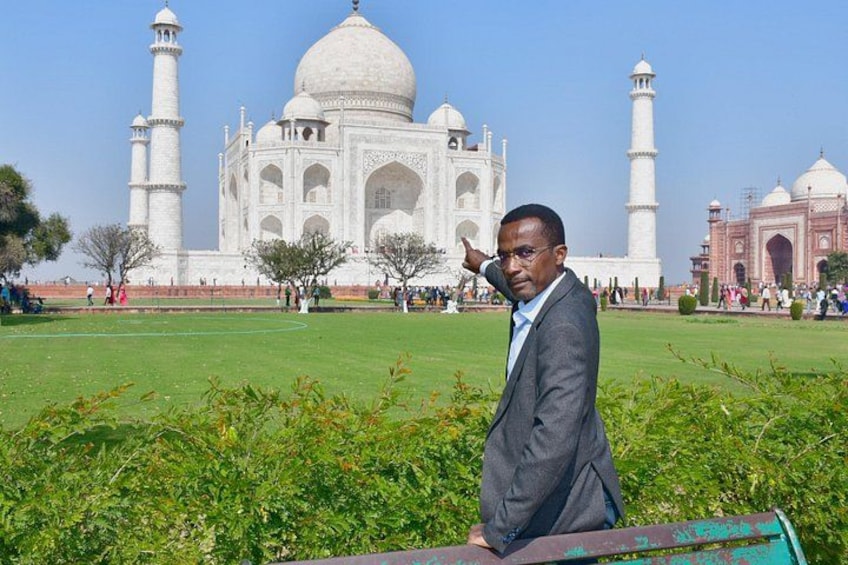 Eine Person steht vor dem Taj Mahal, mit den Kuppeln und Minaretten im Blick. 4