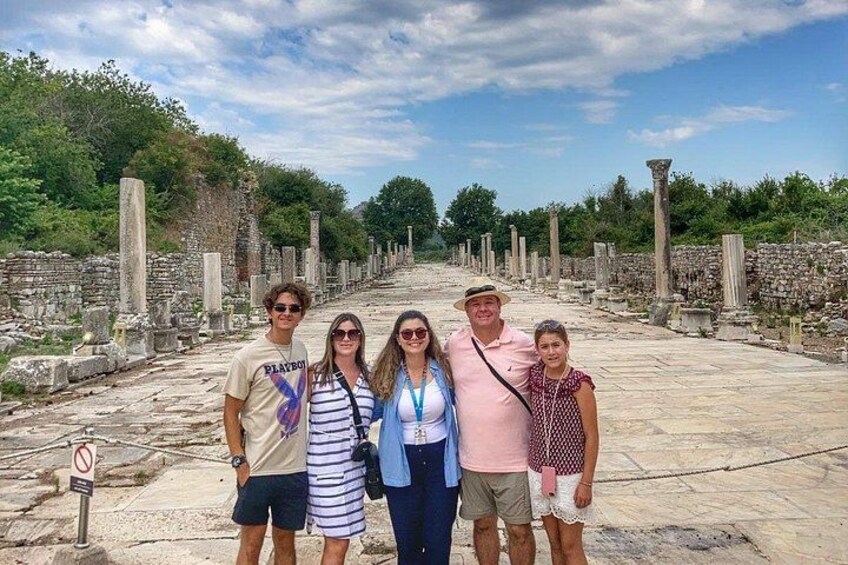 A group of people standing in an ancient ruin with columns and stone structures. 3