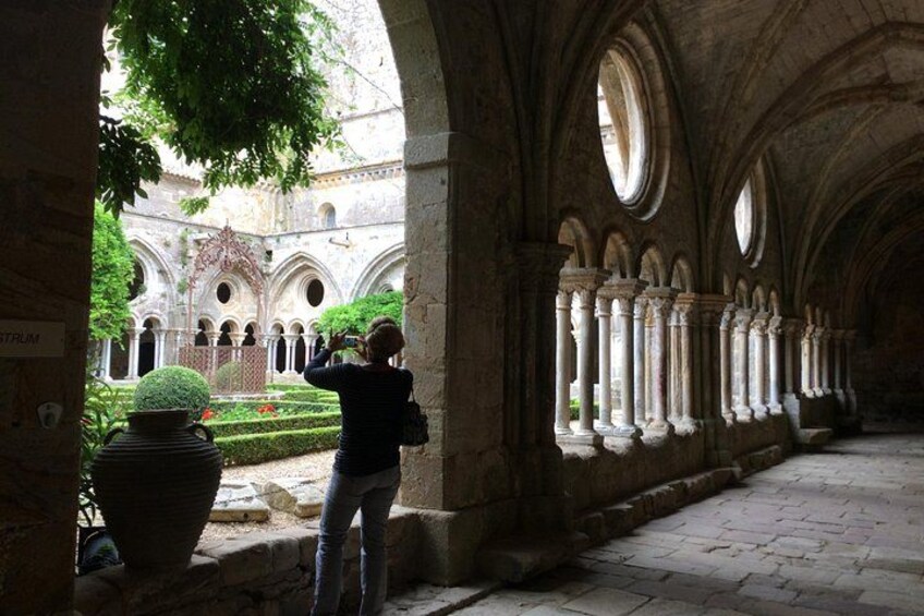 Eine Person fotografiert ein historisches Gebäude mit Bögen und Säulen. 2