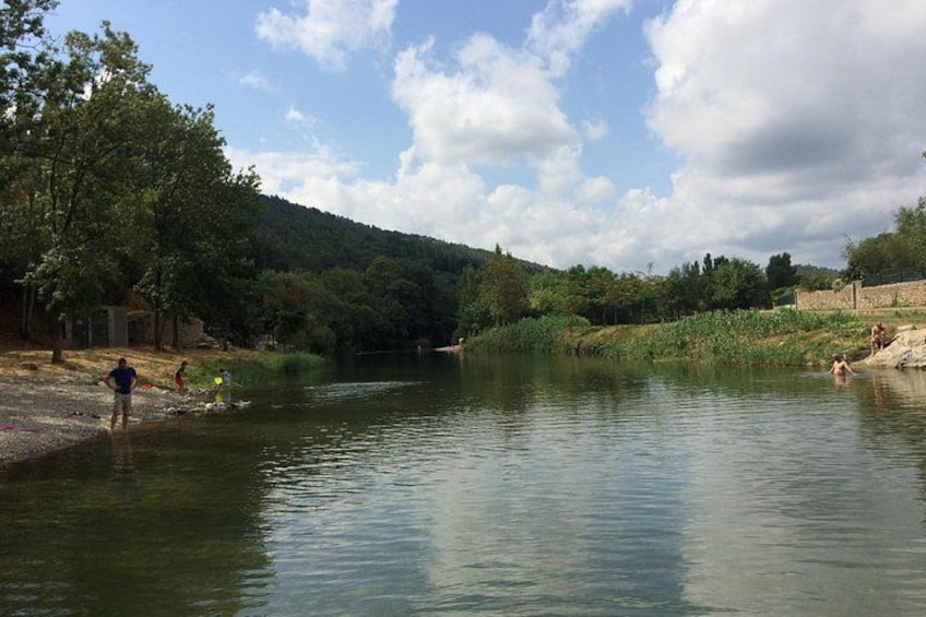 Een rustige rivier met mensen die zwemmen en langs de oever wandelen. 2