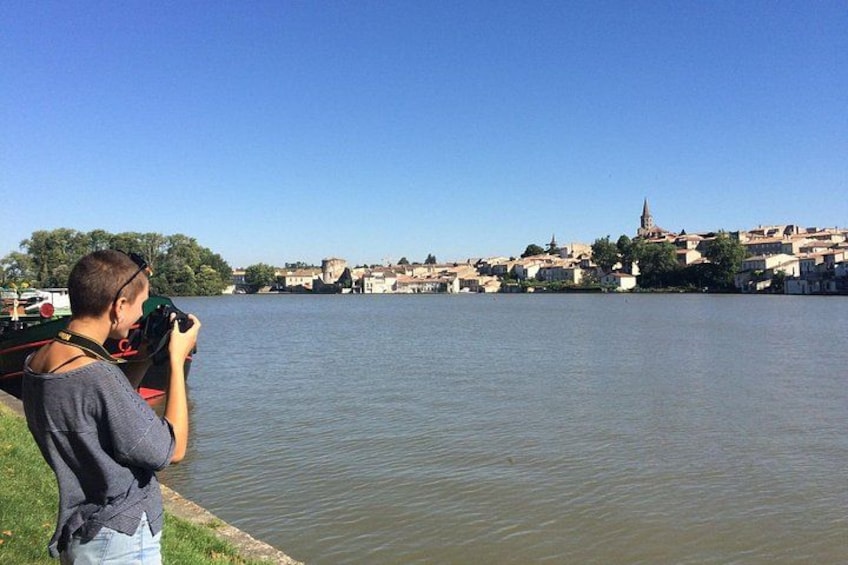 Una persona fotografa un fiume con edifici e una chiesa sullo sfondo. 2