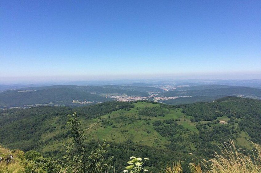 A mountainous landscape with a valley, a small town, and a clear sky. 1