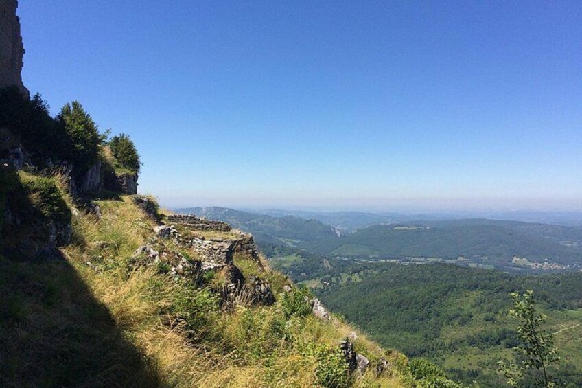 A mountainous landscape with a clear sky, a rocky outcrop, and a valley below. 4