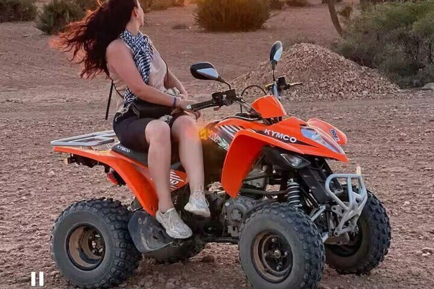A person riding an orange ATV on a dirt path. 4