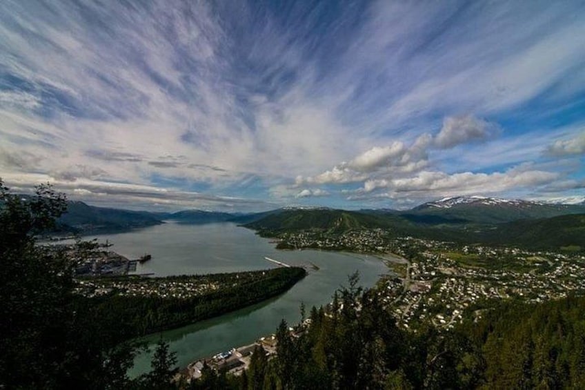 A lake surrounded by mountains, a town, and dense forest. 1