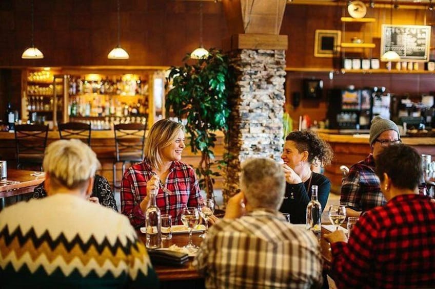 A group of people dining at a restaurant with a bar in the background. 1