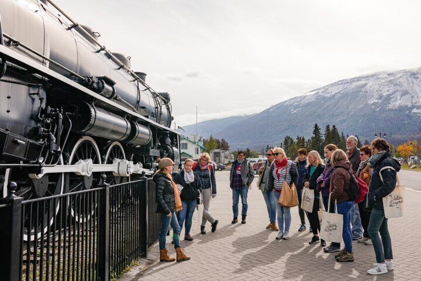 Un grupo de personas de pie frente a una locomotora de vapor. 4