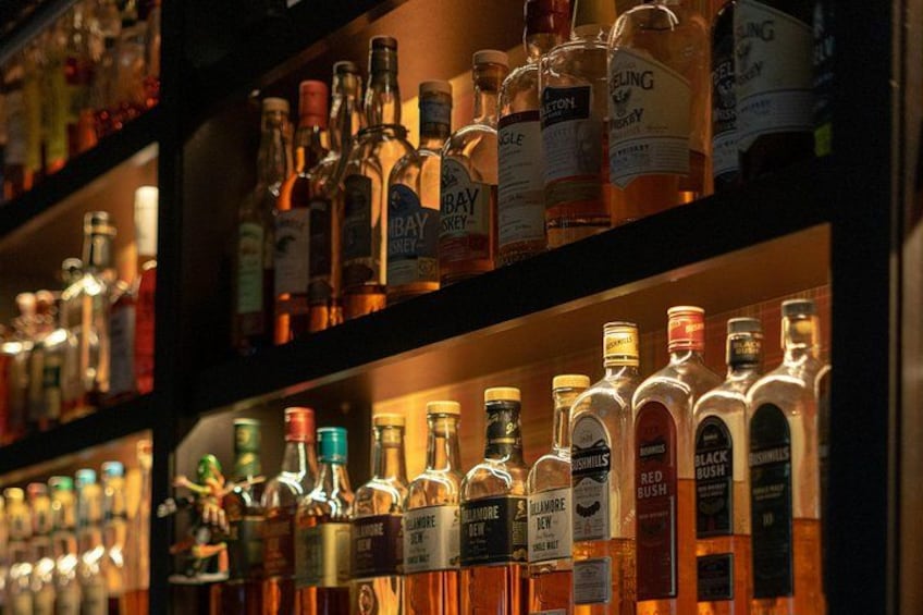 Des étagères remplies de différentes bouteilles de spiritueux. 4