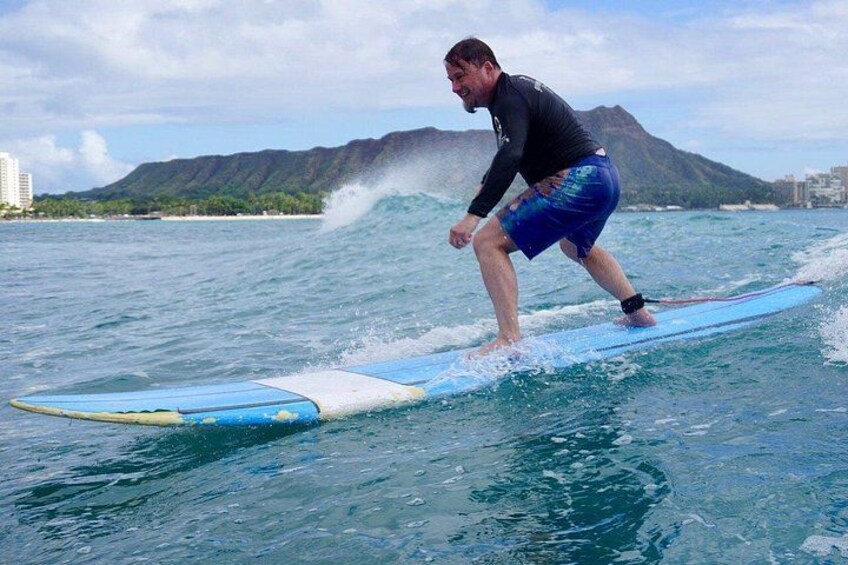 A person surfing on a wave with a mountainous landscape in the background. 2