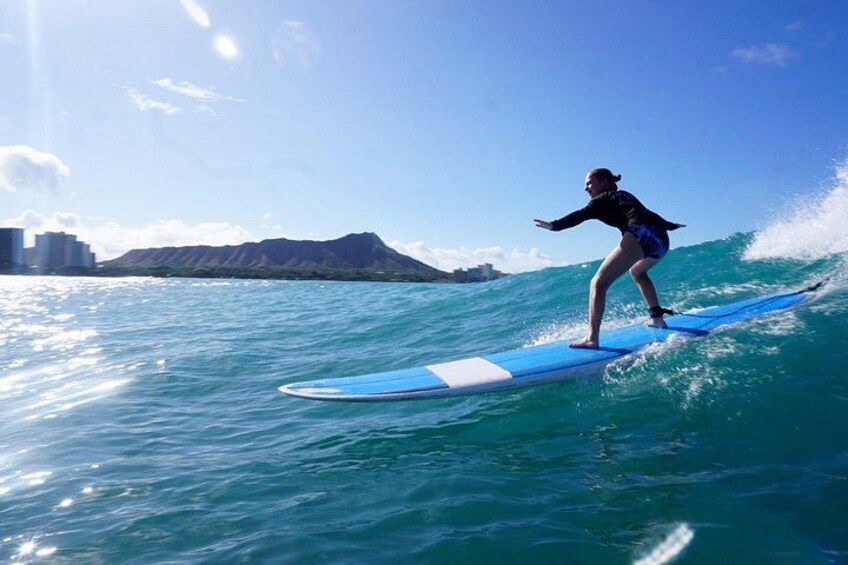 A person surfing on a wave with a mountain in the background. 1