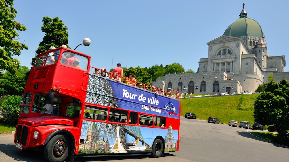 Red Hop On Hop off double-decker bus in front of St. Joseph’s Oratory