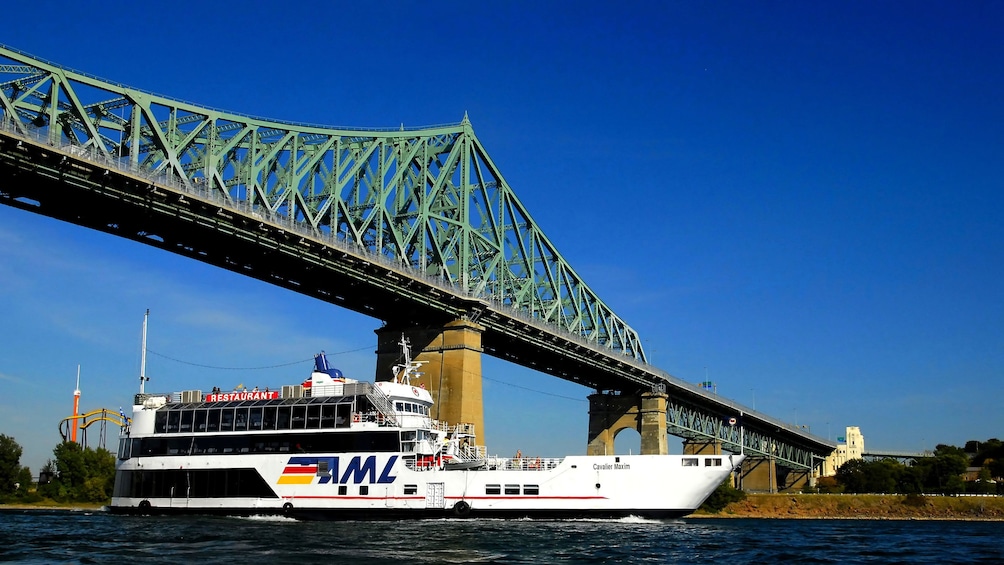 Sightseeing boat passes under the The Jacques Cartier Bridge on the St. Lawrence River