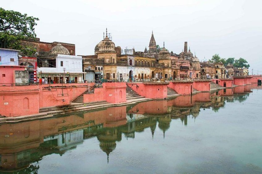 A historic building complex with domed structures and a reflection in the water. 3