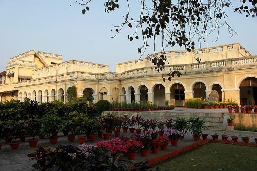 A historic building with multiple arches and a courtyard filled with potted plants. 4