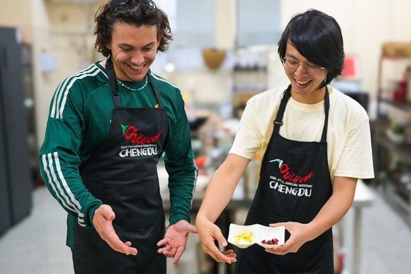 Deux personnes, portant des tabliers sur lesquels est inscrit le nom « CHENGDU », se tiennent dans une cuisine. 2