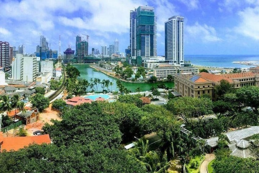 A cityscape with high-rise buildings, a river, and a beach. 1