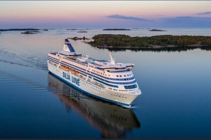 A large cruise ship named 'SILJA LINE' sailing on calm waters with a forested island in the background. 4