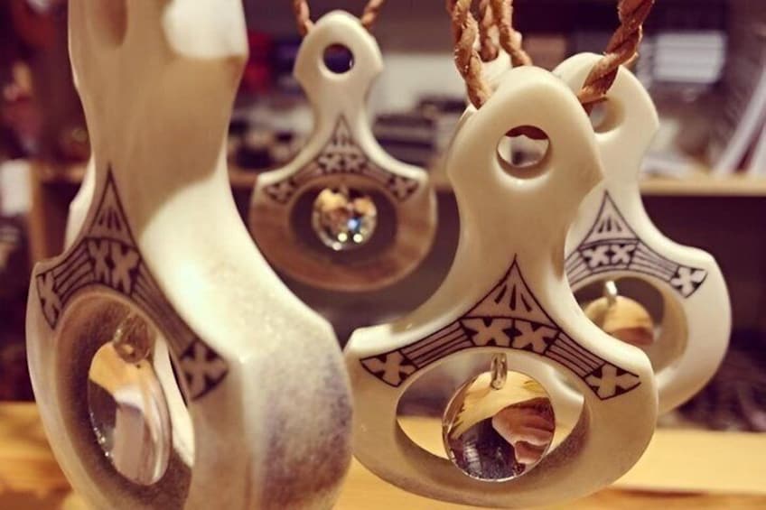 A close-up of intricately carved wooden pendants with geometric patterns and a central hole. 2