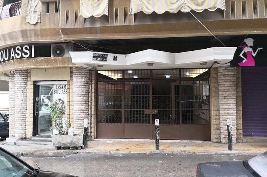 A storefront with a sign that reads 'OUASSI' and a large window display. 3