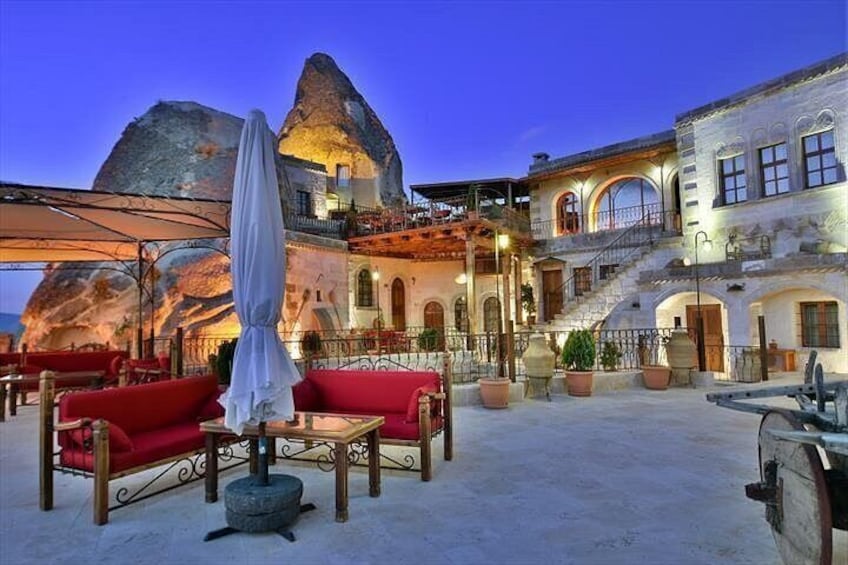 A coastal building with a rock formation, outdoor seating, and a staircase. 2