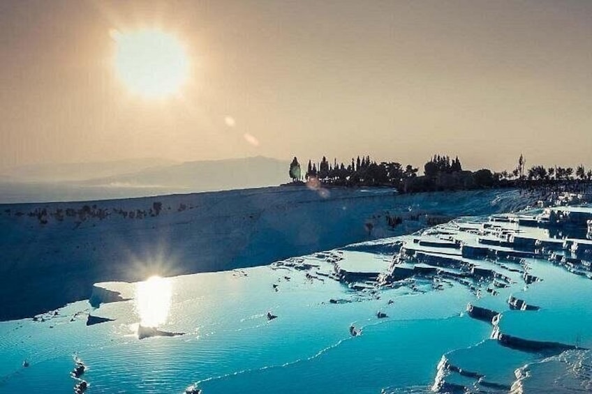 Terraced pools, a sunlit landscape, and distant trees. 4