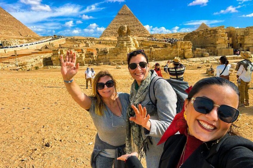 Tourists at the Giza pyramid complex with the Great Pyramid and Sphinx in the background. 2