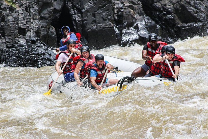 Un groupe de personnes à bord d’un radeau naviguant sur une rivière à courant rapide. 1