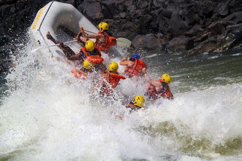 Un groupe de personnes à bord d’un radeau naviguant sur une rivière aux eaux agitées. 4