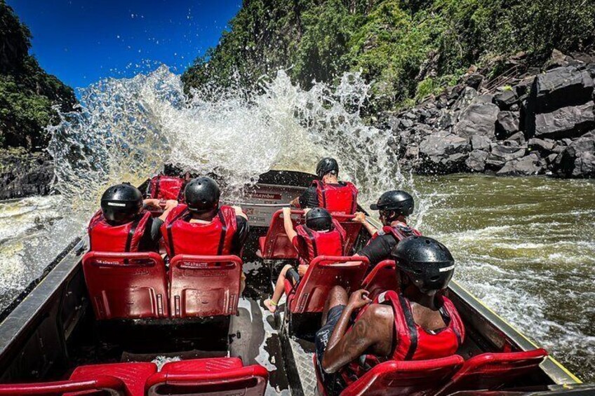 Un groupe de personnes à bord d’un radeau naviguant sur une rivière à courant rapide. 1