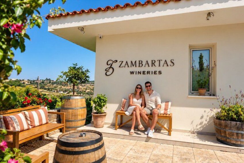 Ein Weingut namens Zambartas, mit einem Paar, das auf einer Bank draußen sitzt. 3