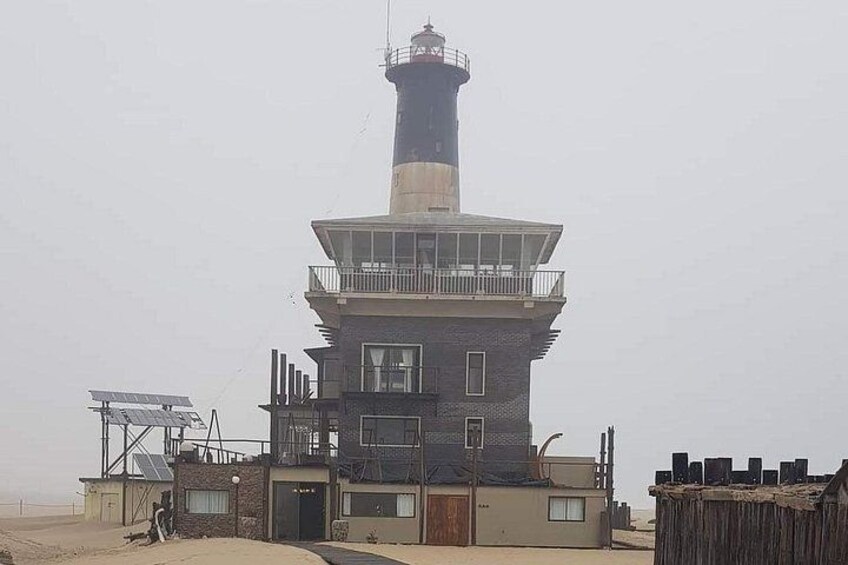 Ein Leuchtturm mit mehrstöckiger Struktur, einem Kontrollturm und Solaranlagen. 4