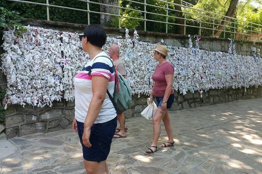 People walking along a path with a wall covered in newspapers. 5