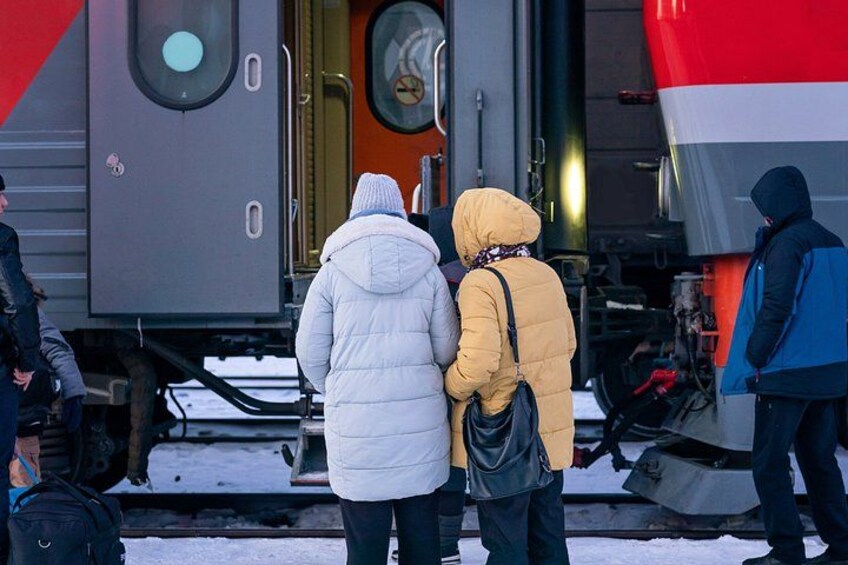 A train station platform with a train in the background. 2