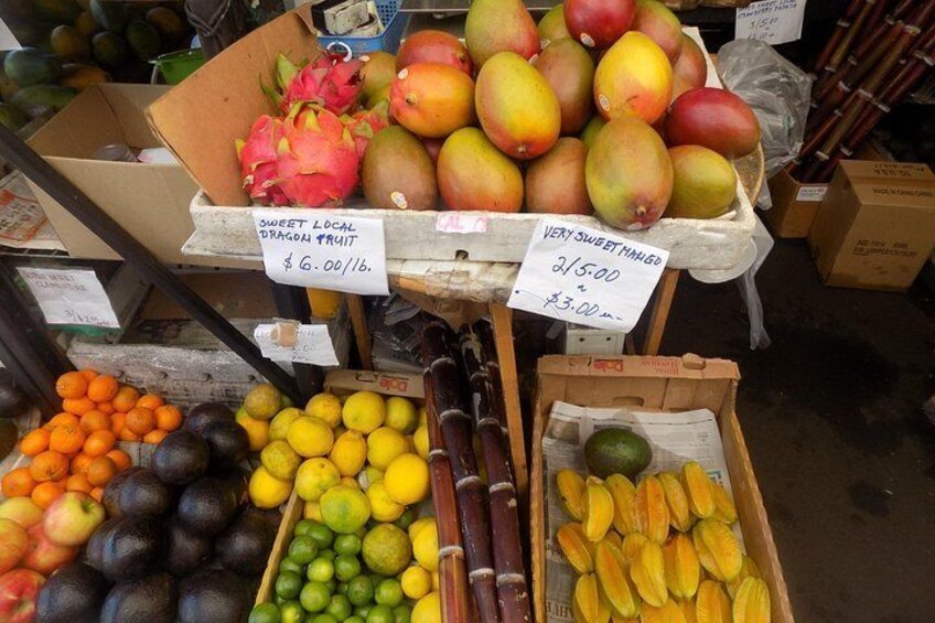 Un puesto de frutas con pitahaya, mangos, naranjas, aguacates, limones y limas. 1
