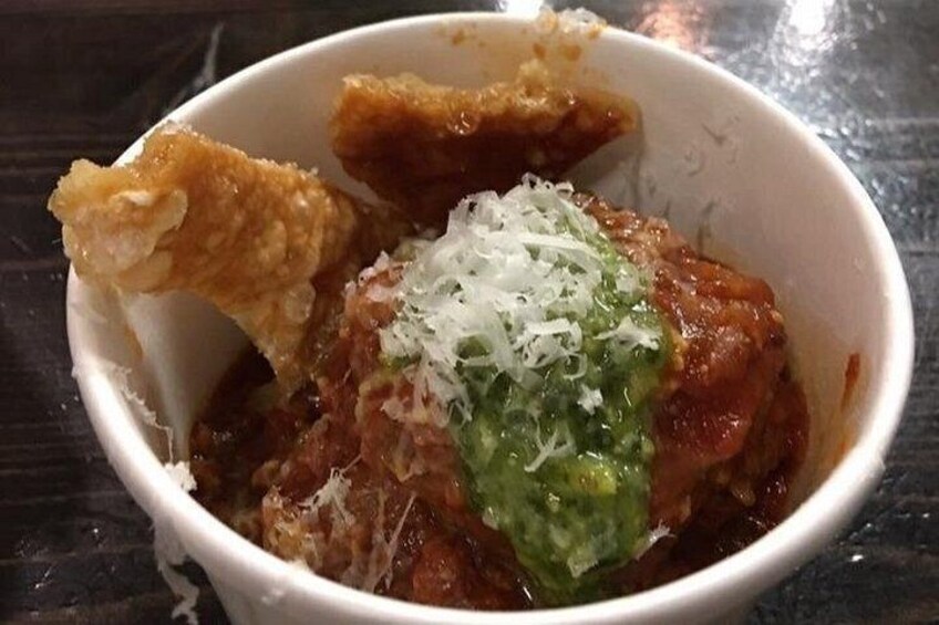 A bowl of food with a piece of bread and grated cheese. 4