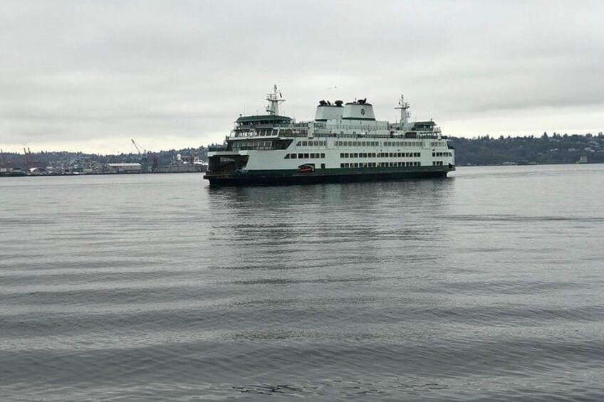 A large ferry boat on calm water with a cloudy sky. 2
