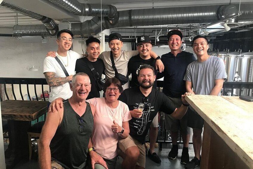 Un grupo de personas en una cocina con electrodomésticos de acero inoxidable y encimeras de madera. 4