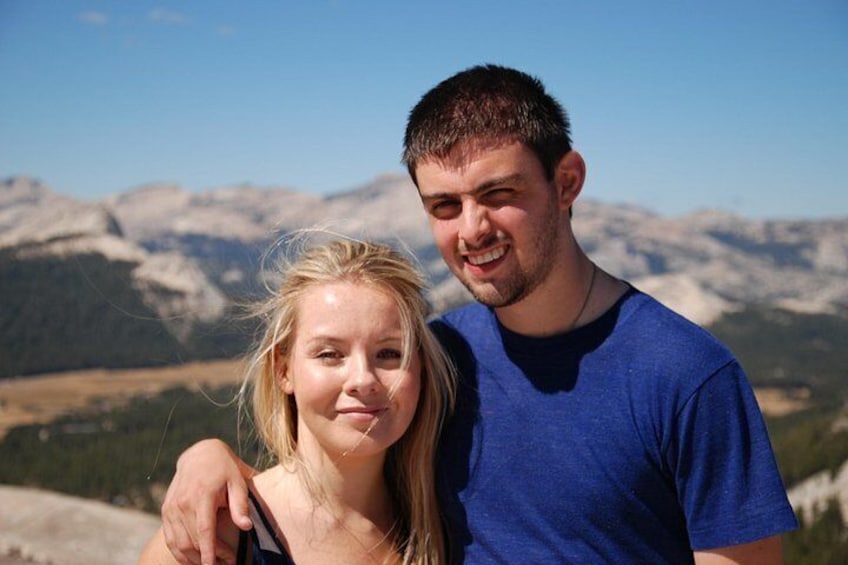 A person standing with a mountainous landscape in the background. 4