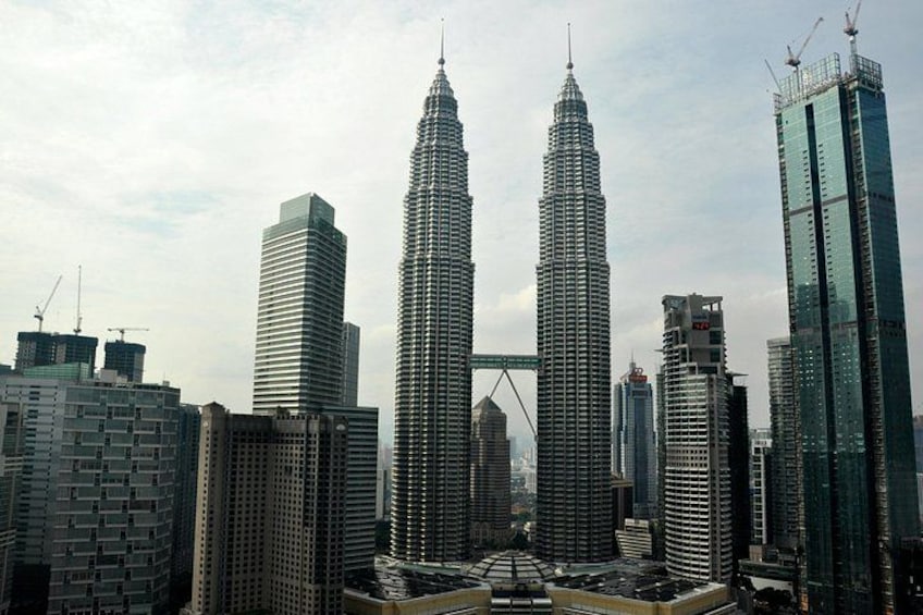 Stadsbeeld met de Petronas Twin Towers, een brug en omliggende moderne gebouwen. 2