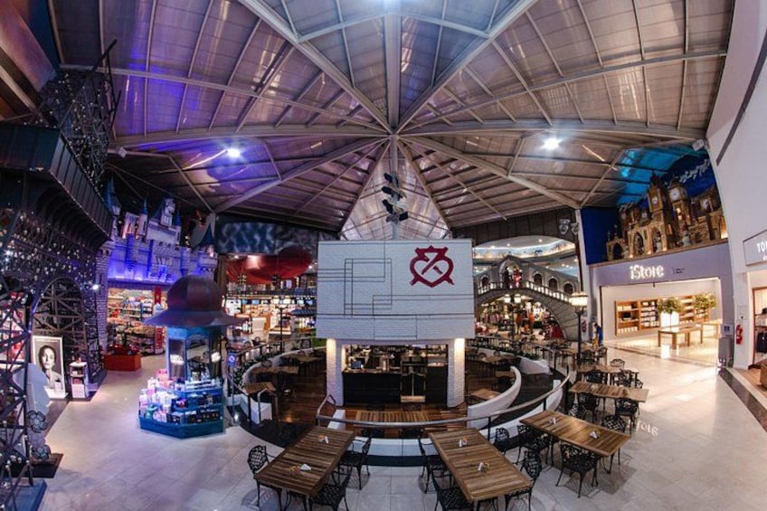 Een modern winkelcentrum met een centrale atriumruimte, diverse winkels en zitgedeeltes. 5