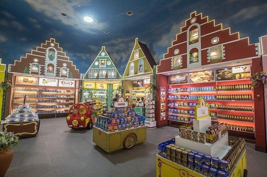 Een helder verlichte overdekte markt met diverse kraampjes en etalages. 3