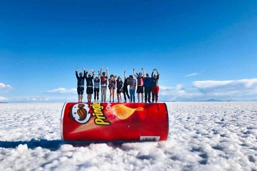 En grupp människor står på ett snötäckt landskap, och i förgrunden syns en burk Pringles. 4